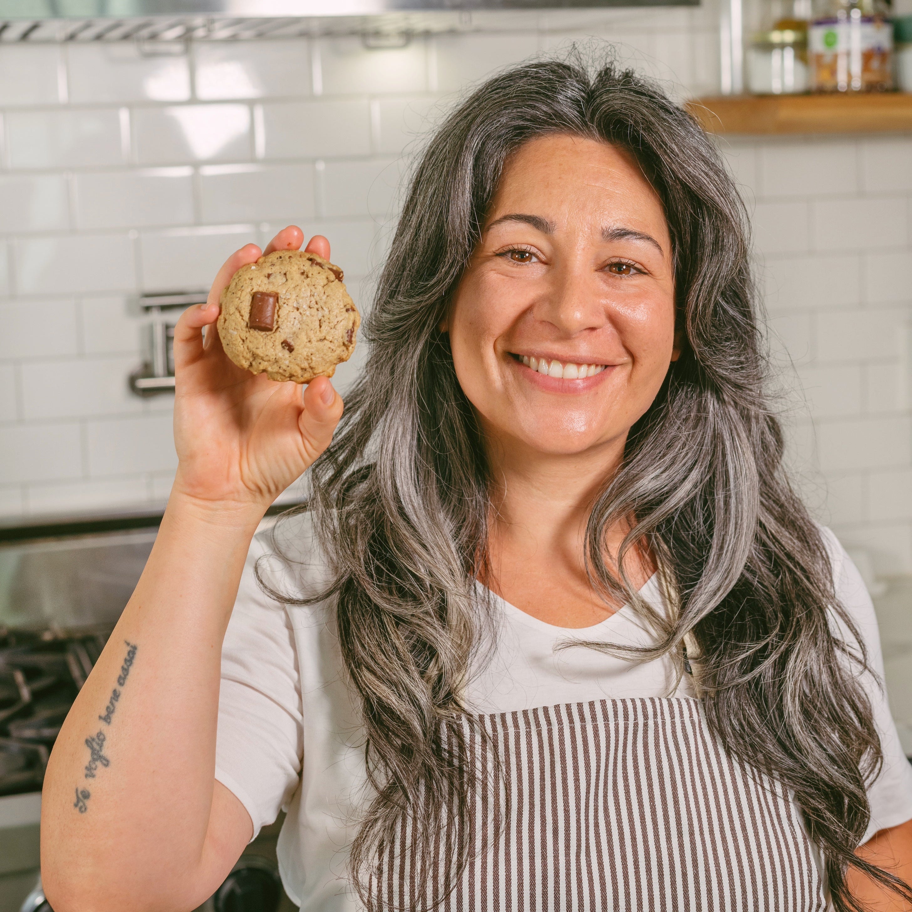 Woman holding a cookie in a kitchen